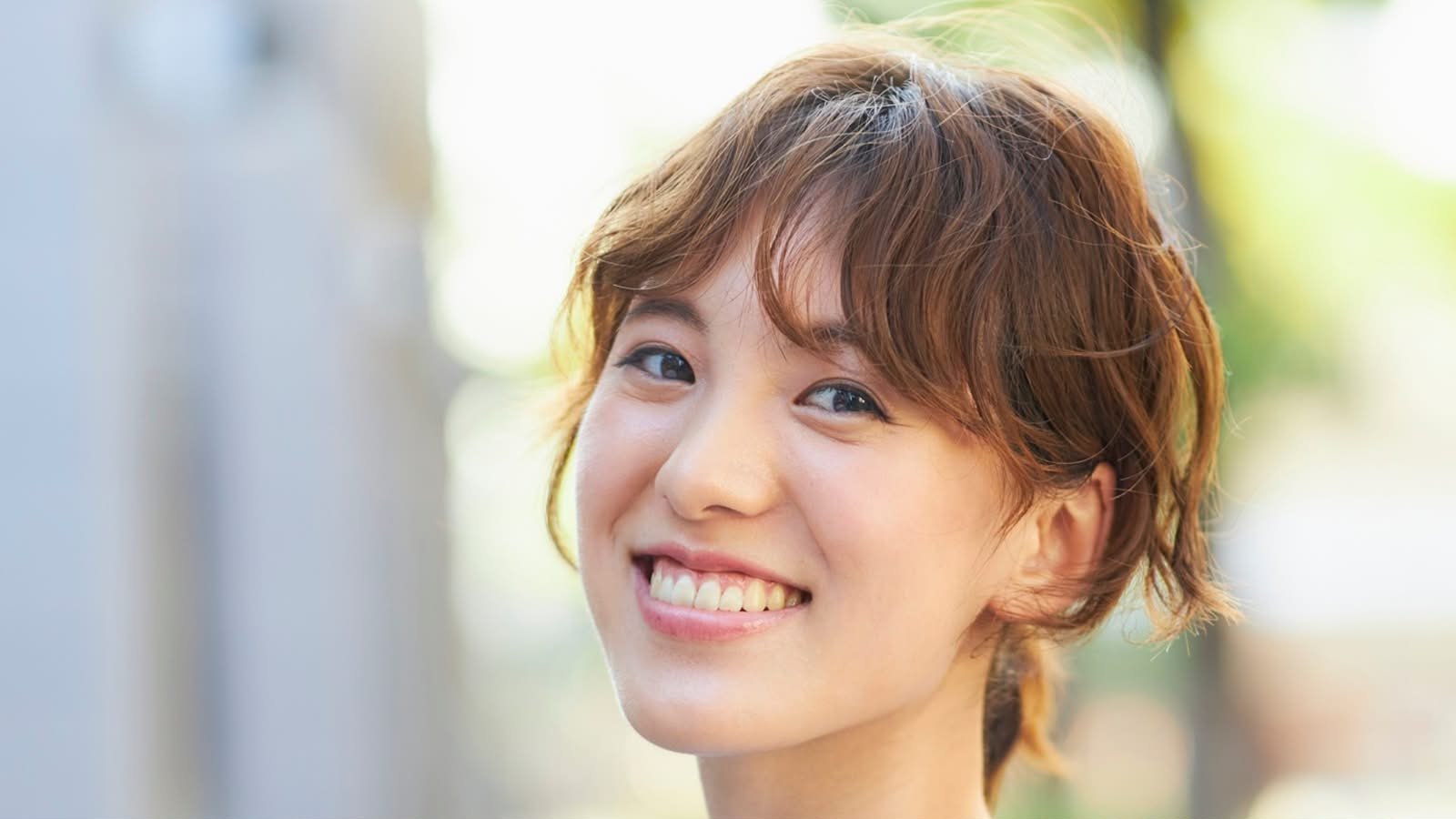 Smiling woman illustrating tooth-coloured restorative care